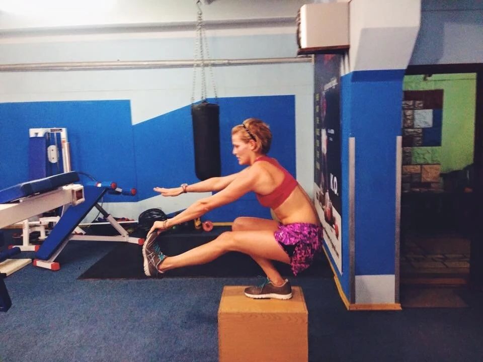 Series of stretching and flexibility exercises being performed in a blue-walled fitness studio.
