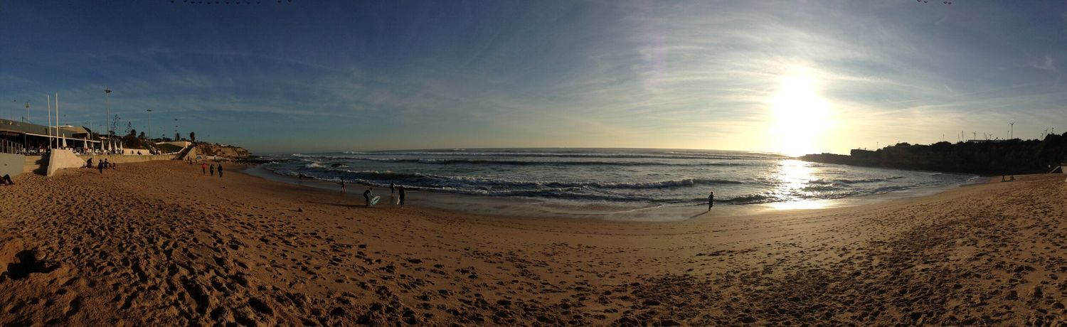Panoramic sunset view over a beach coastline with golden light reflecting on the ocean.