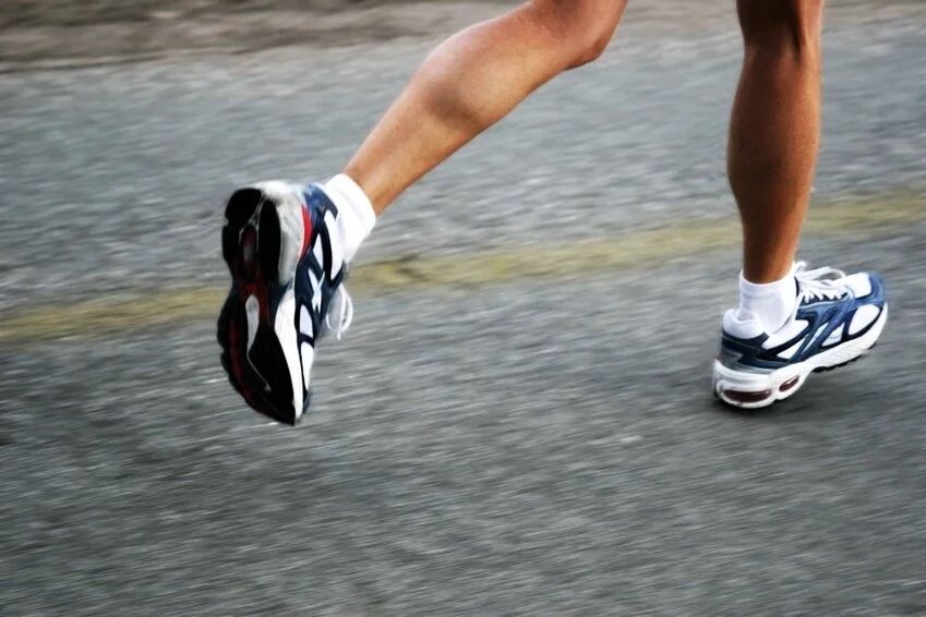 Close-up sequence of running shoes in motion on wet ground.