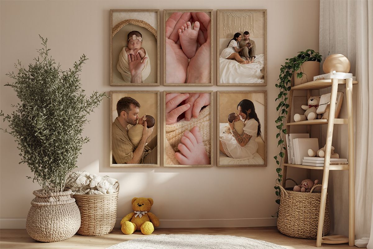 A warm nursery wall gallery featuring framed newborn and family photos in natural wood frames above a basket and toys.
