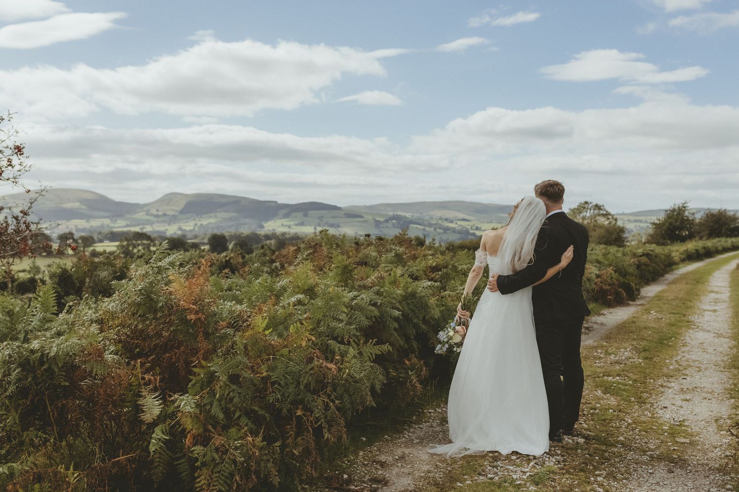 Bride and groom during couple photos overlooking welsh mountains