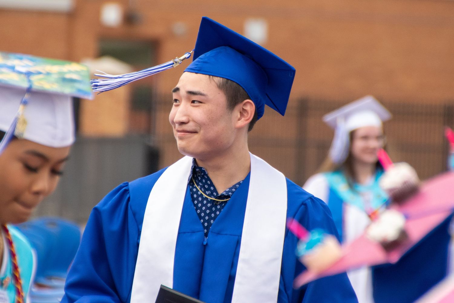 Graduate during ceremony smiling at crowd