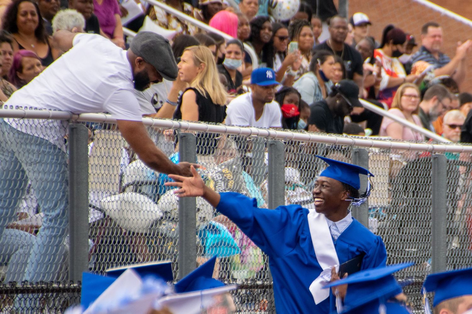 Graduate high-fiving family member during ceremony
