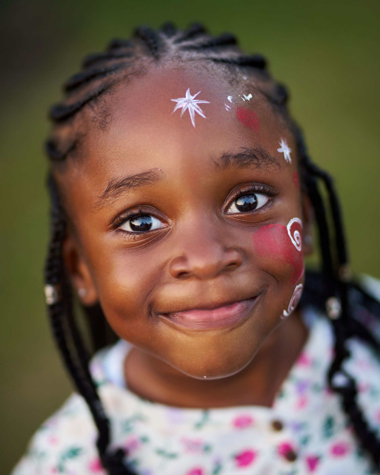 Close-up portrait sequence with face paint decorations and braided hairstyle.