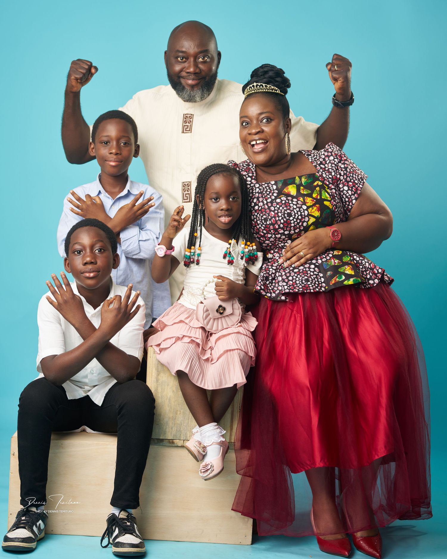 Portrait of a happy family posing together against a blue background.