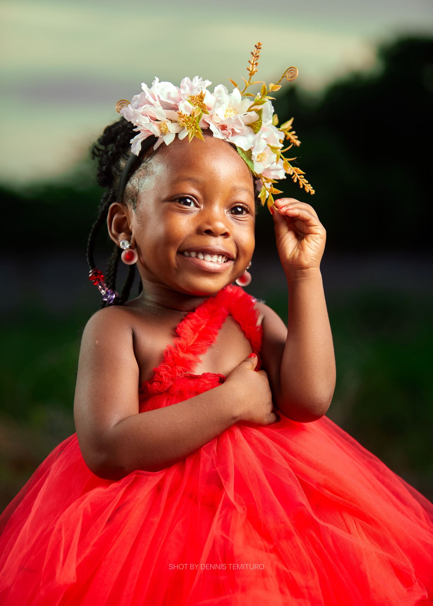 A series of joyful poses in a red tulle dress with white floral crown against a blurred outdoor background.