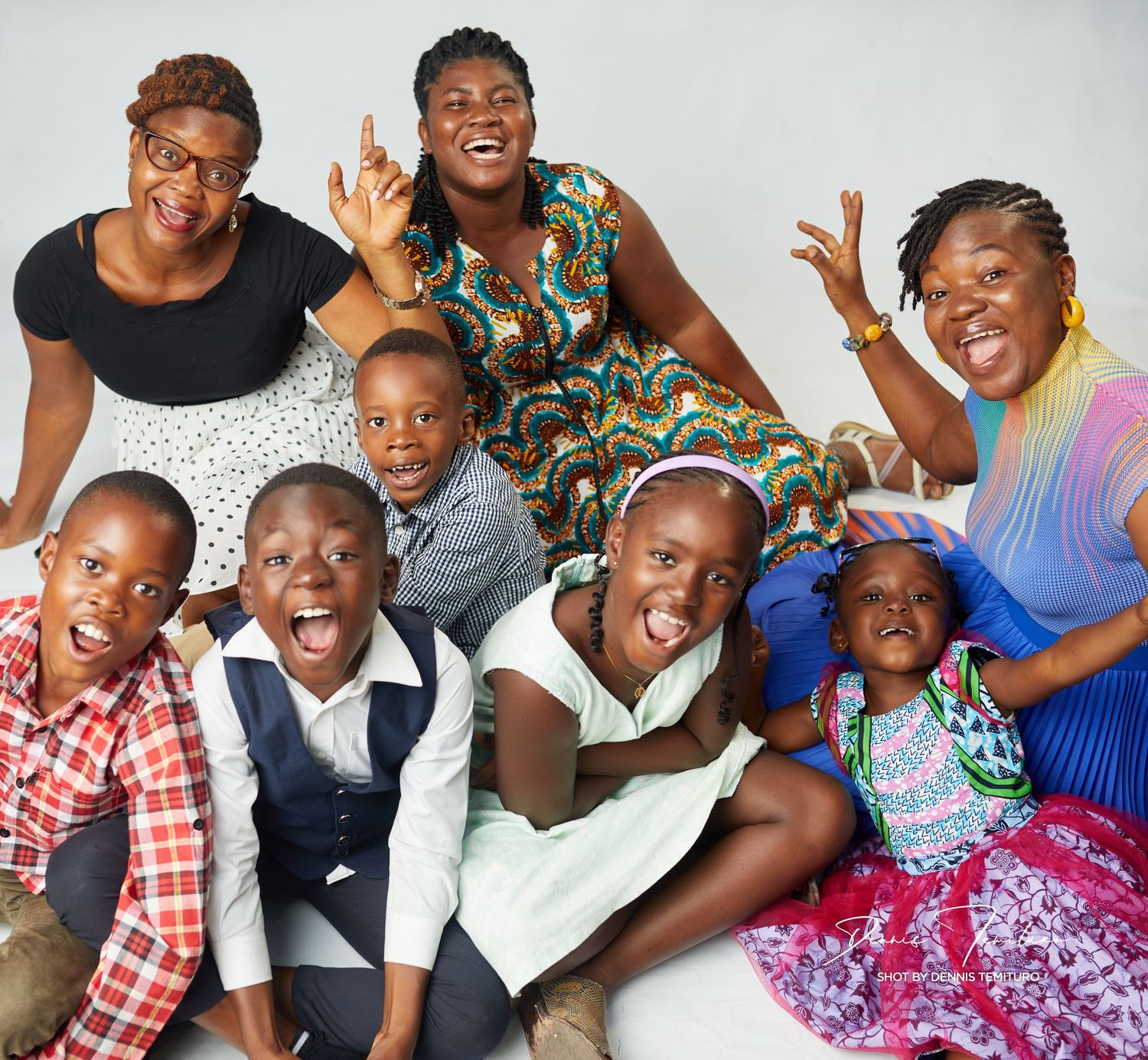 Group photo of people in colorful outfits expressing joy and excitement.