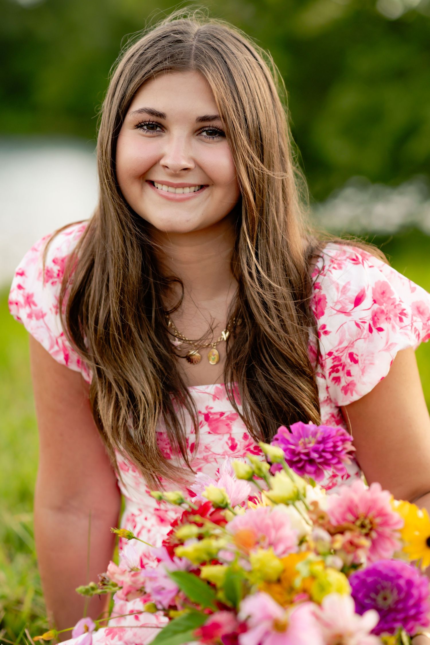 Summer portrait featuring flowers and a pink floral dress in a sunny garden setting.