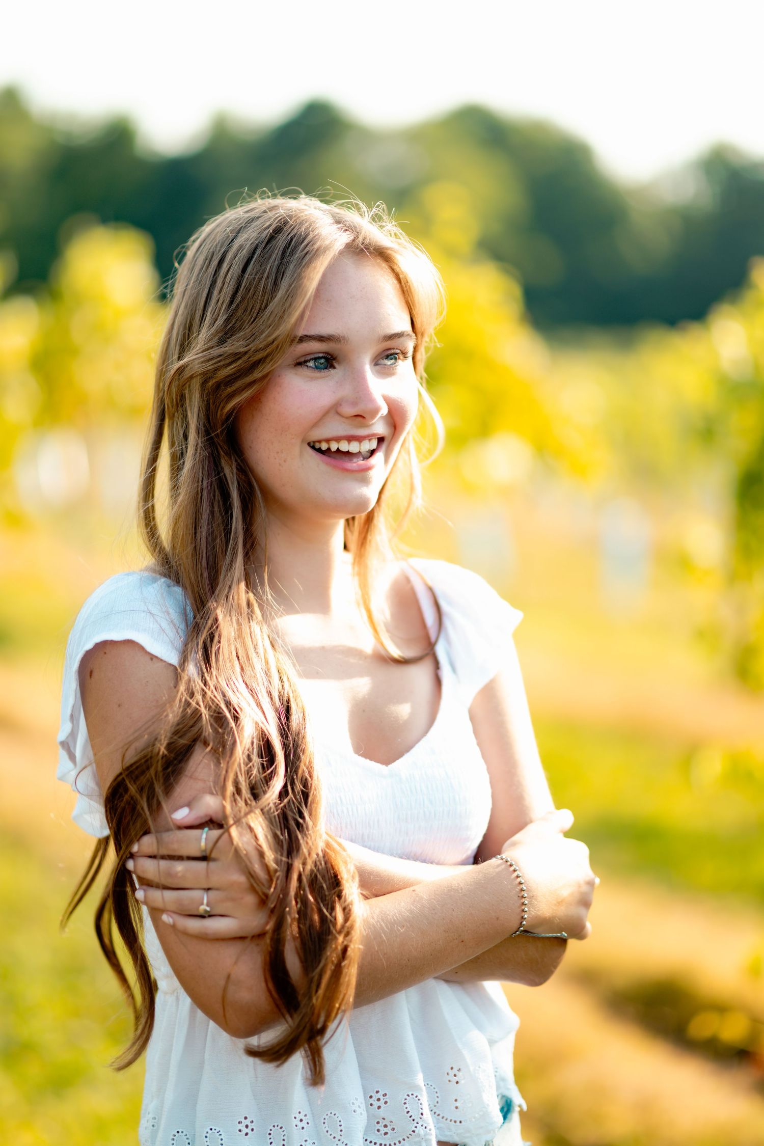 Candid summer portraits in white dress against golden sunlit background.