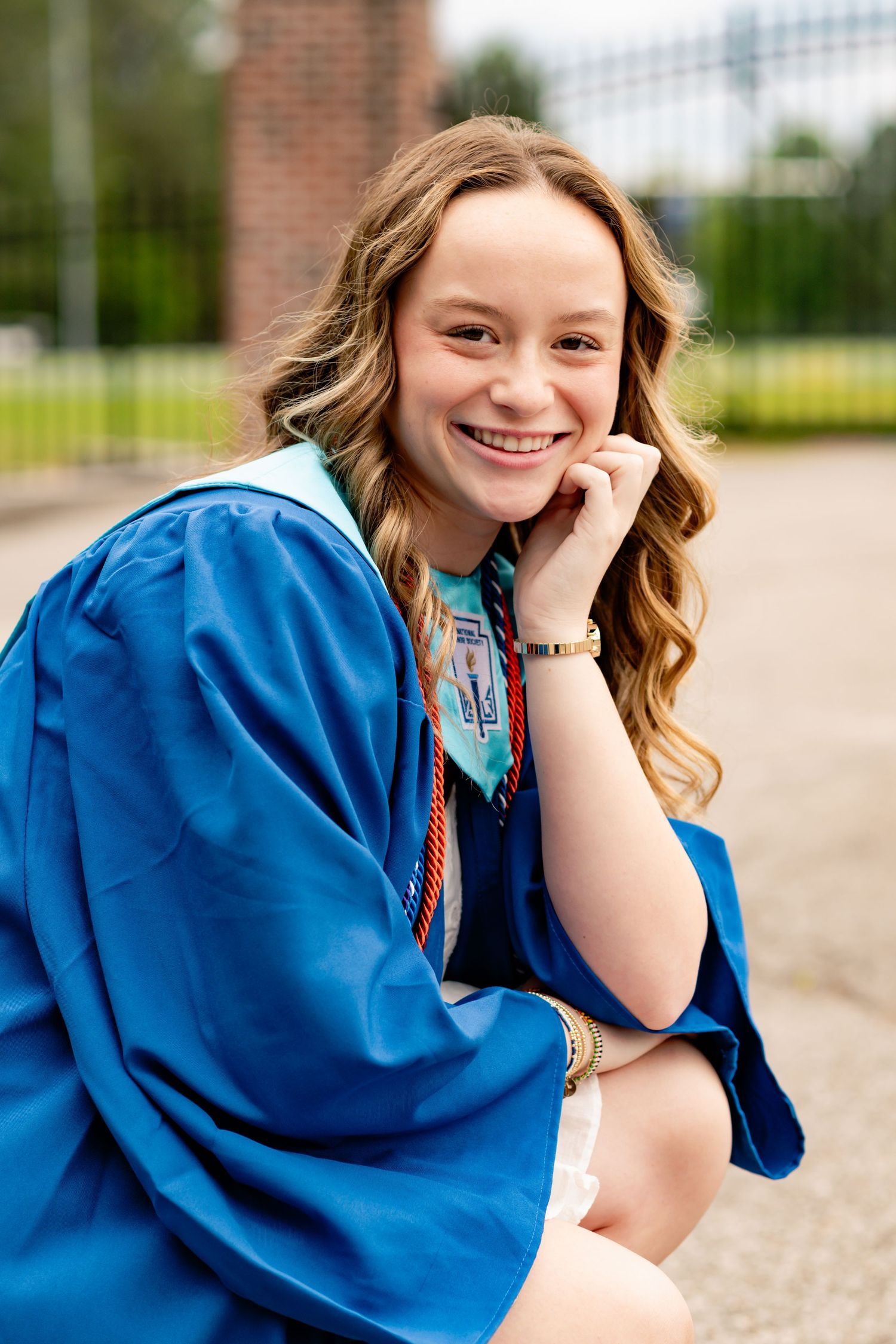 Candid graduation portrait series showing joyful expressions in blue academic regalia.