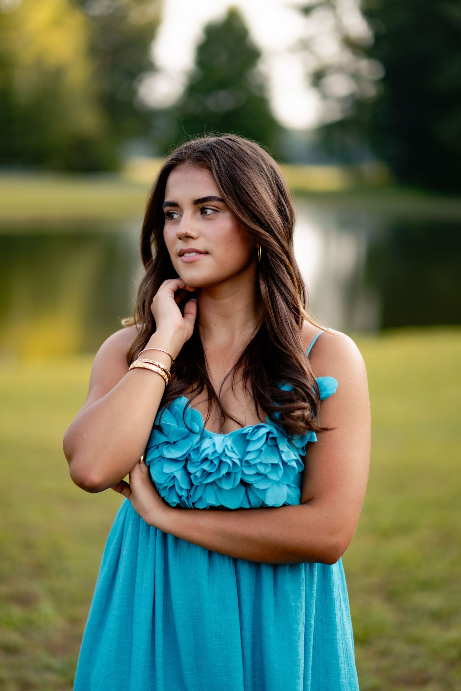 Artistic portrait series in a flowing turquoise dress against a natural outdoor background.