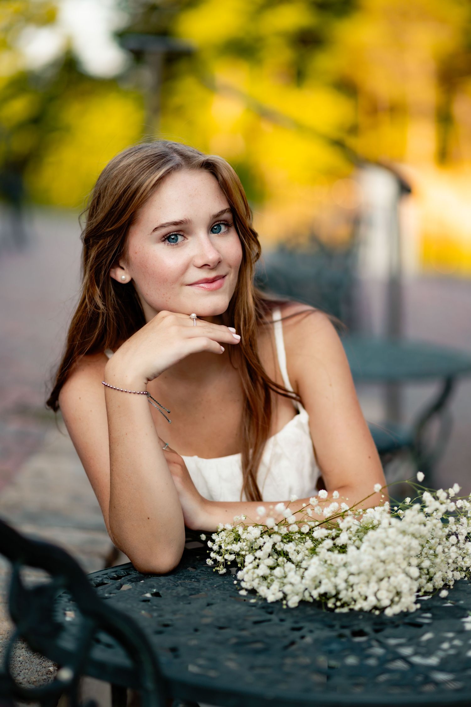 Artistic portrait featuring white baby's breath flowers and soft natural lighting outdoors.