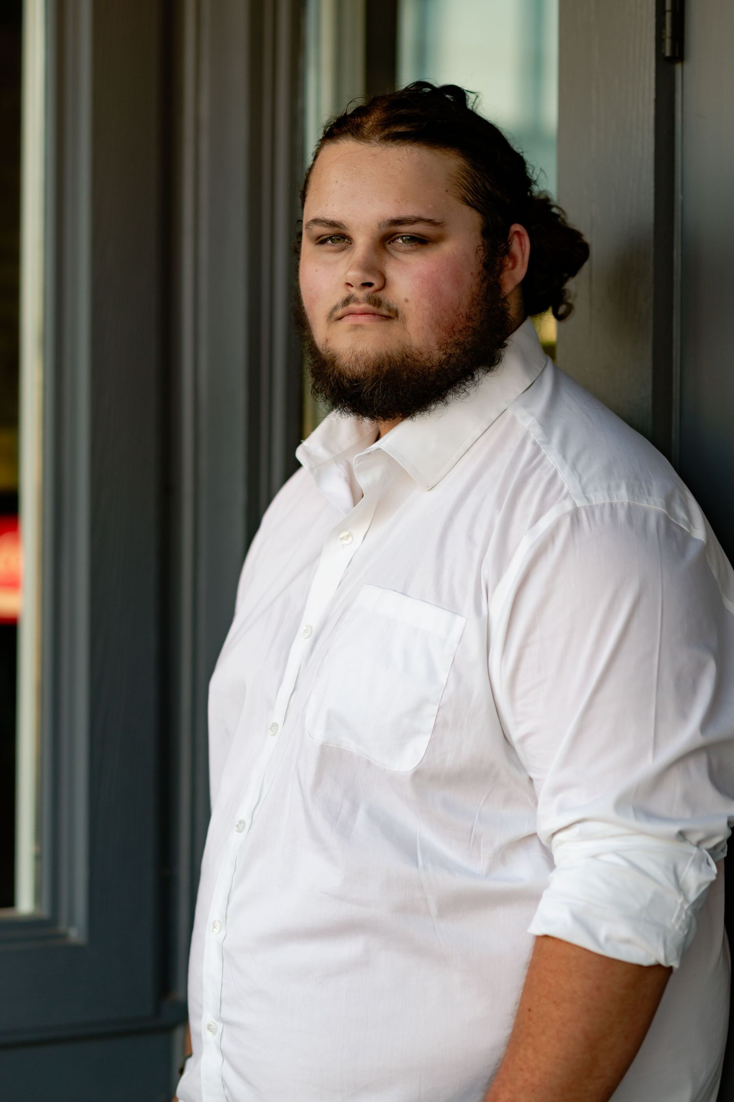 Side profile portraits in white button-down shirt against gray background showing different angles.