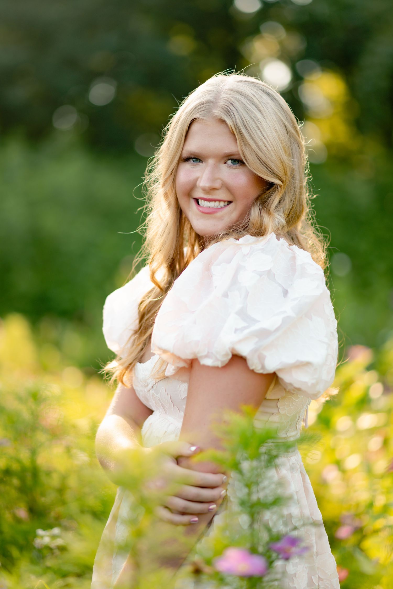 A collection of outdoor portraits in a sunny meadow shows playful poses with puffy white dresses among wildflowers.