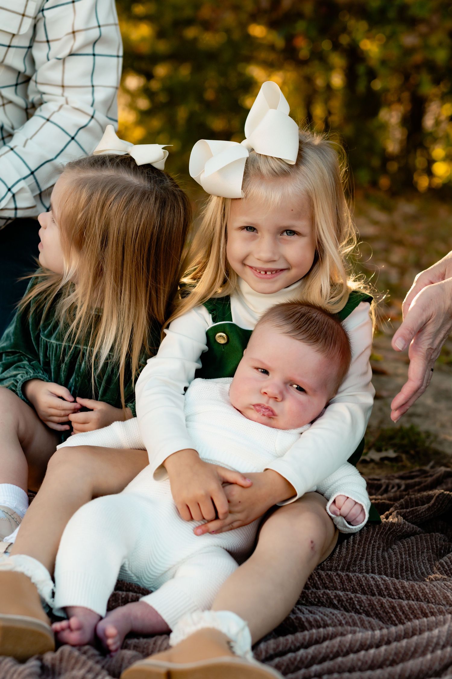 A series of candid outdoor photos on a brown blanket showing sweet cuddles and tender moments in autumn lighting.