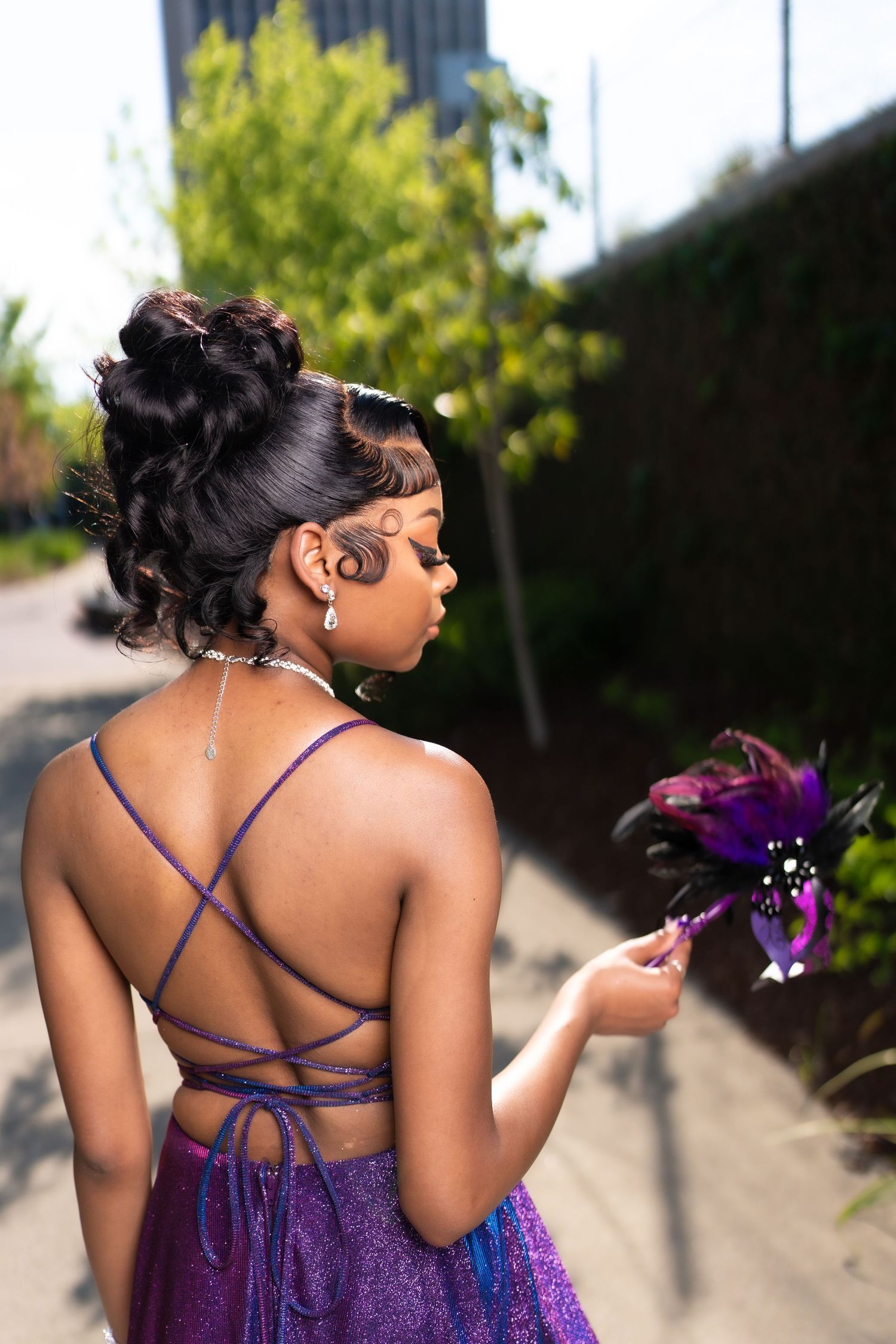 Back view of purple formal dress showing intricate criss-cross strap detail.