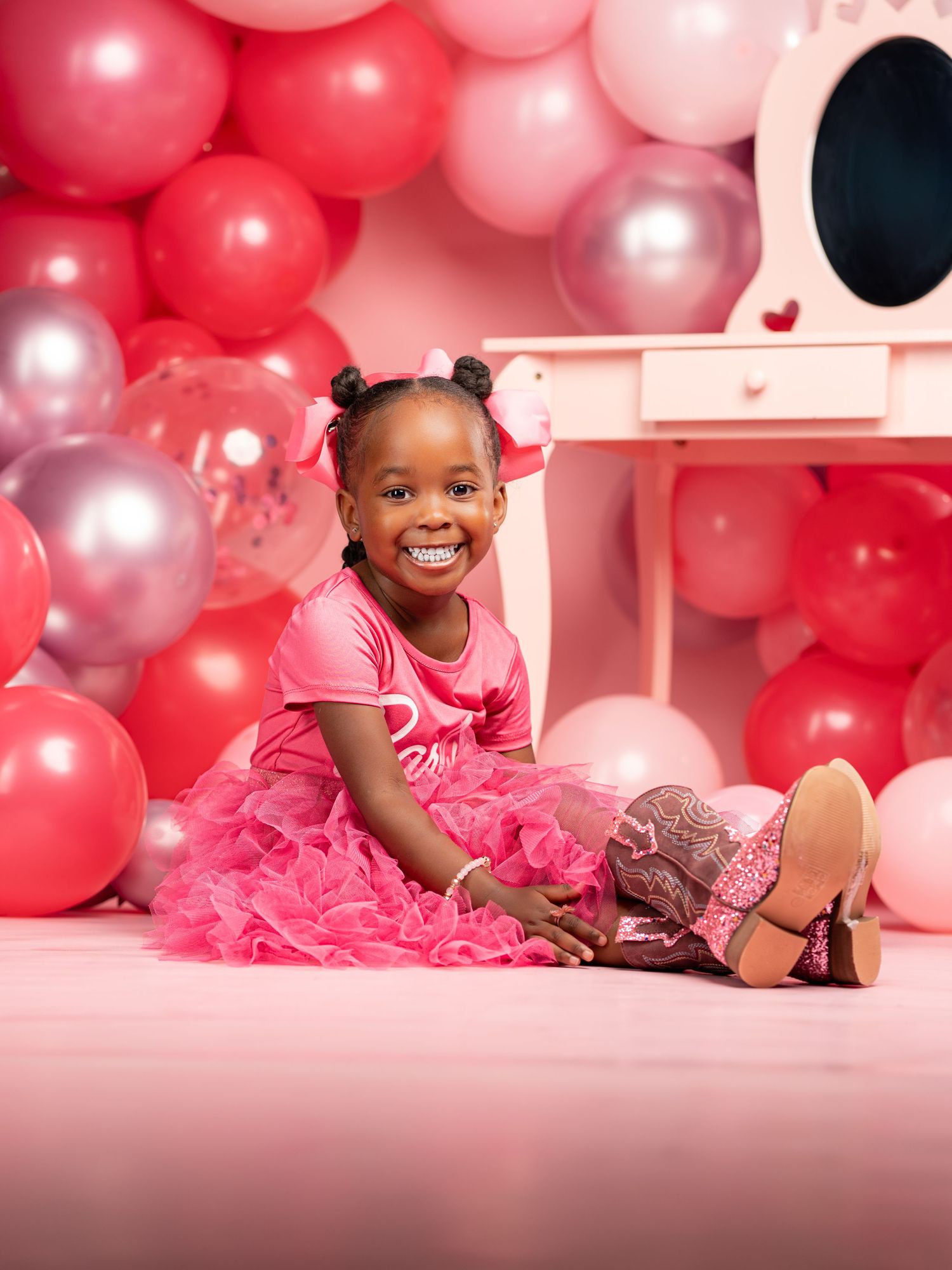 Festive pink party setup with balloons and tulle dress creating a dreamy atmosphere.