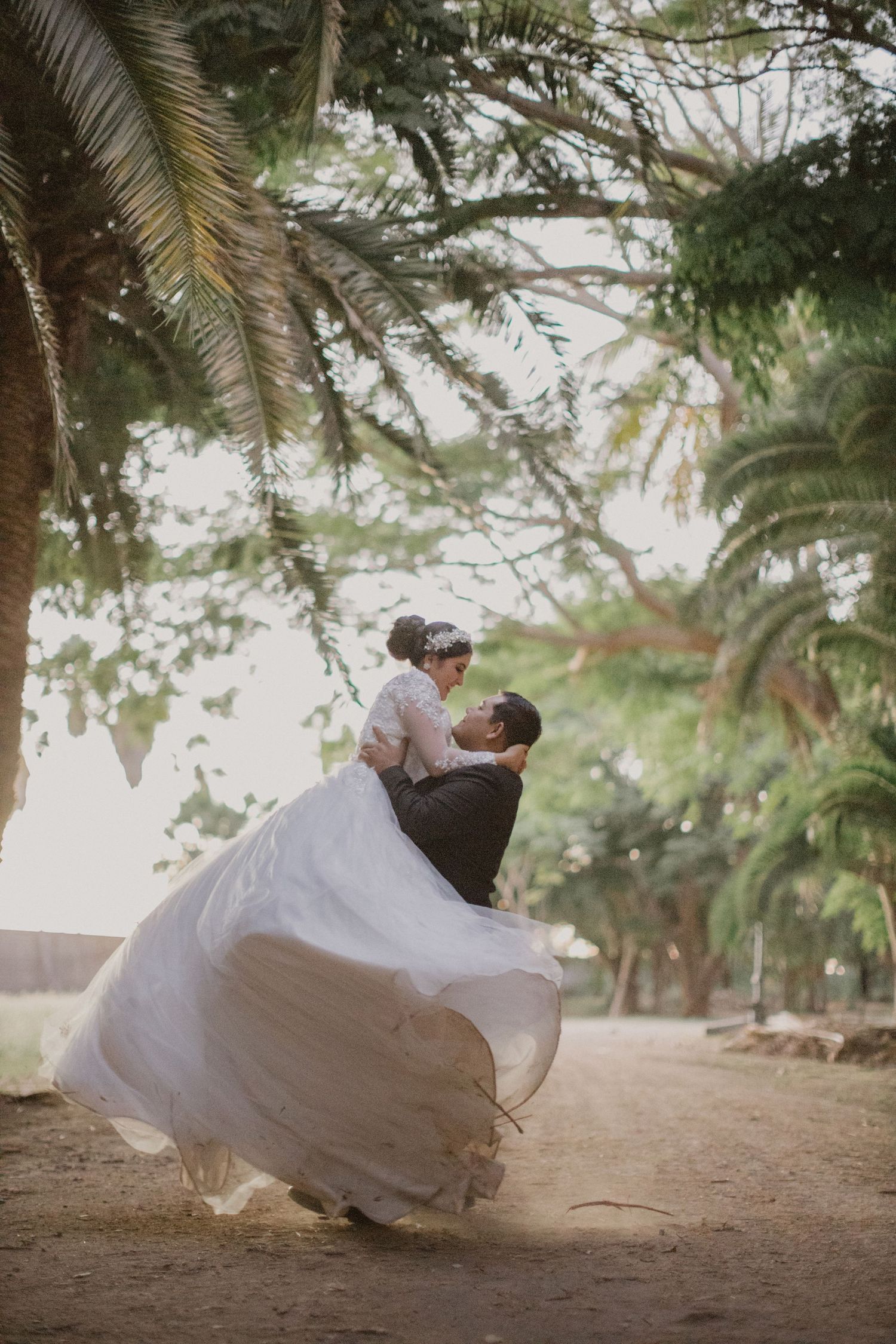 A romantic dance lift moment captured during a tropical wedding photoshoot.