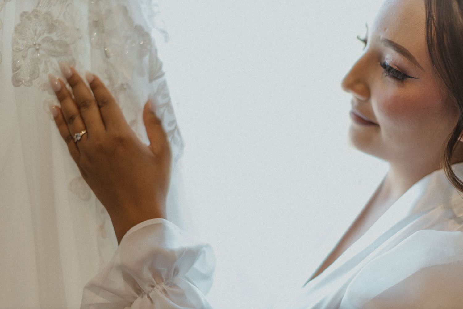Close-up artistic shots of someone touching a delicate white wedding veil.