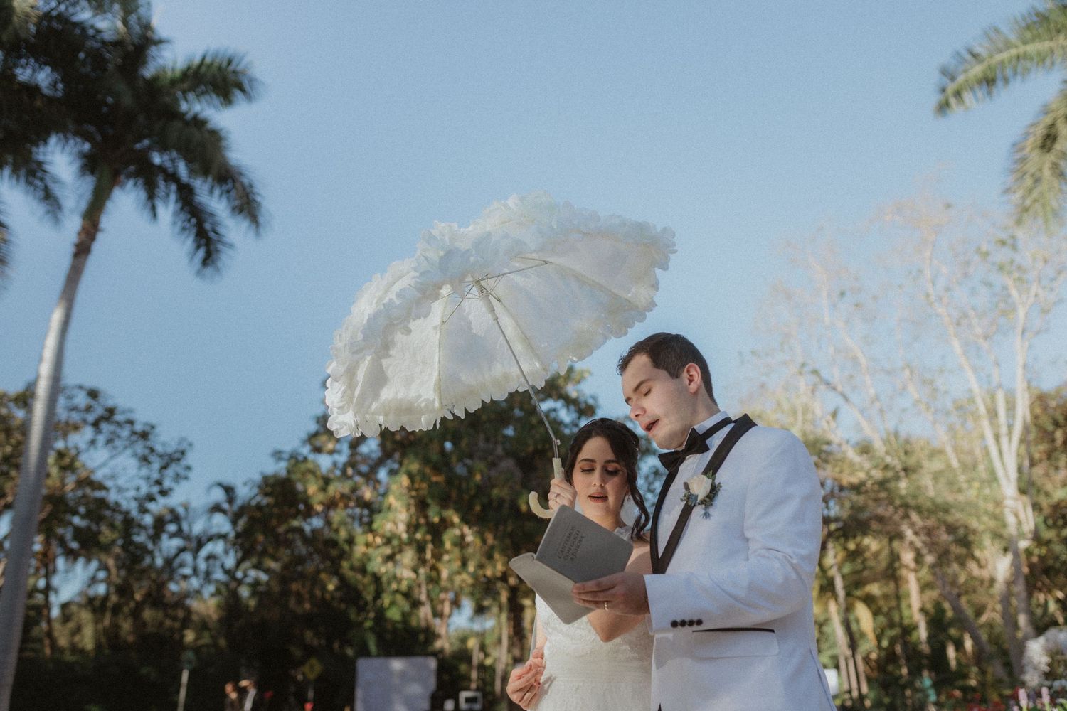 Garden wedding scene with tropical palm trees in the background.
