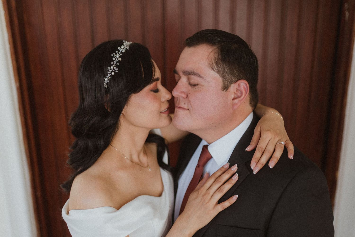 An intimate wedding portrait showing a tender moment between newlyweds.