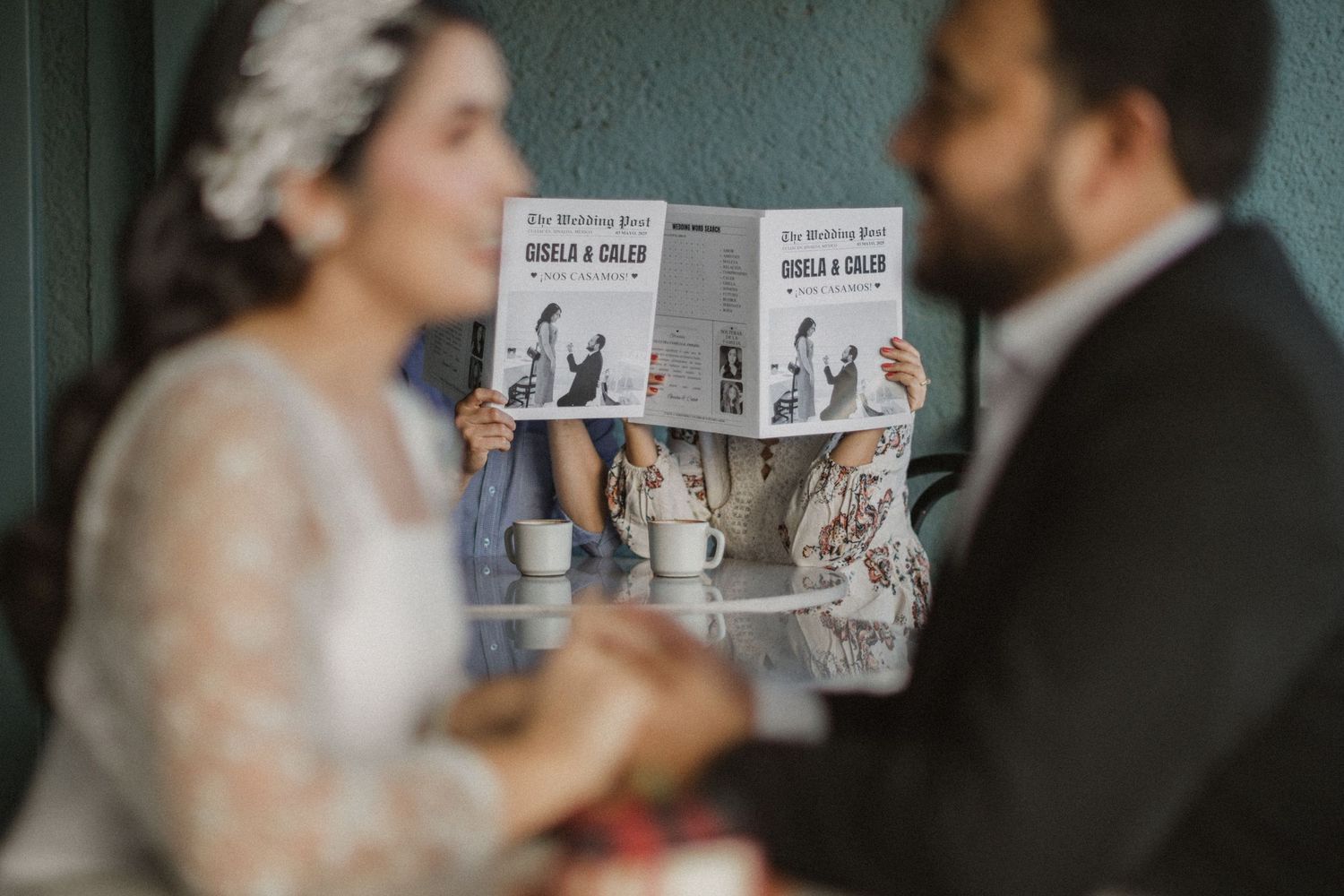 Wedding couple poses behind newspaper during intimate photoshoot.