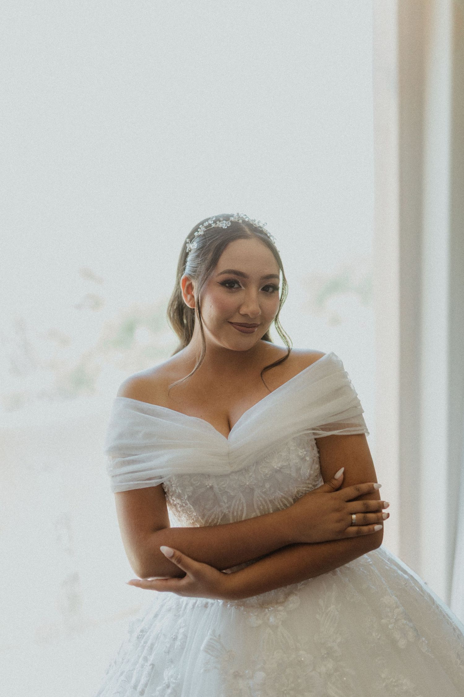 Close-up shots of a bride in a classic white ball gown dress holding herself in an emotional moment.
