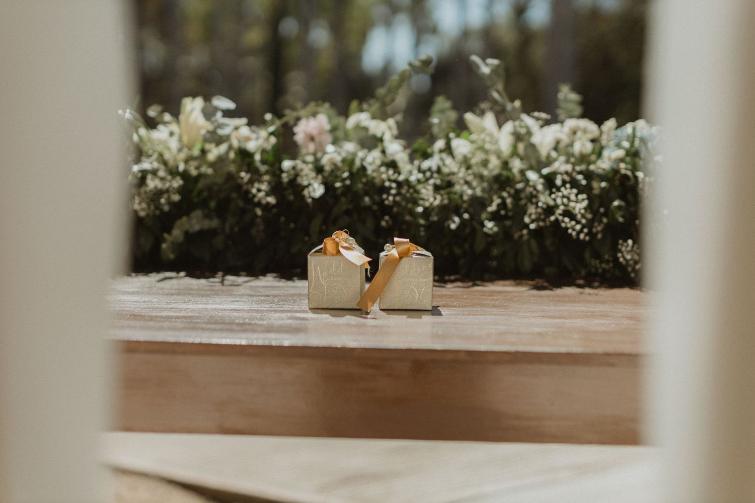 Rustic wedding table setting with white floral centerpieces and natural decor elements.