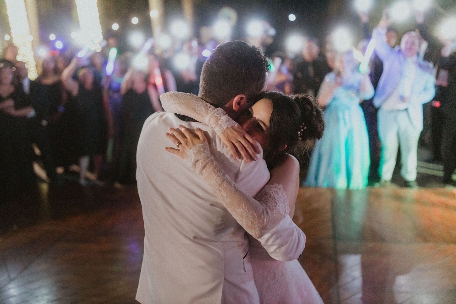 A couple embraces during an emotional dance moment at their wedding reception.