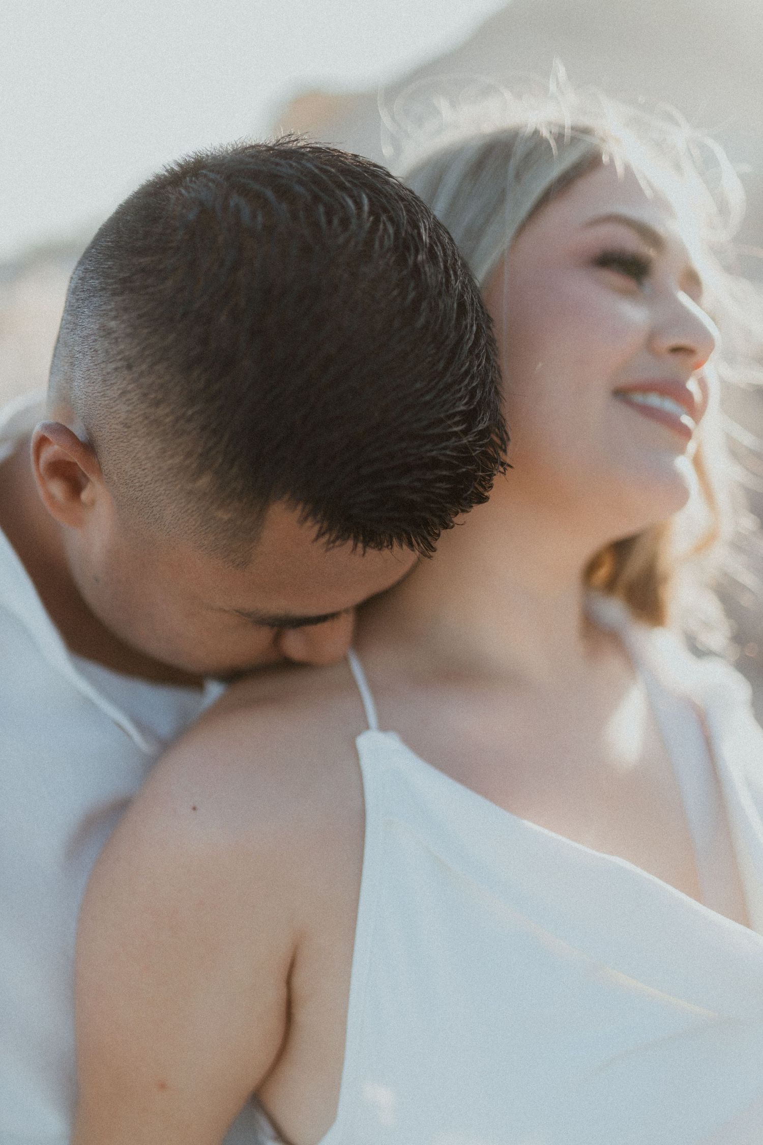 Intimate close up portrait showing romantic moment between couple in soft lighting.