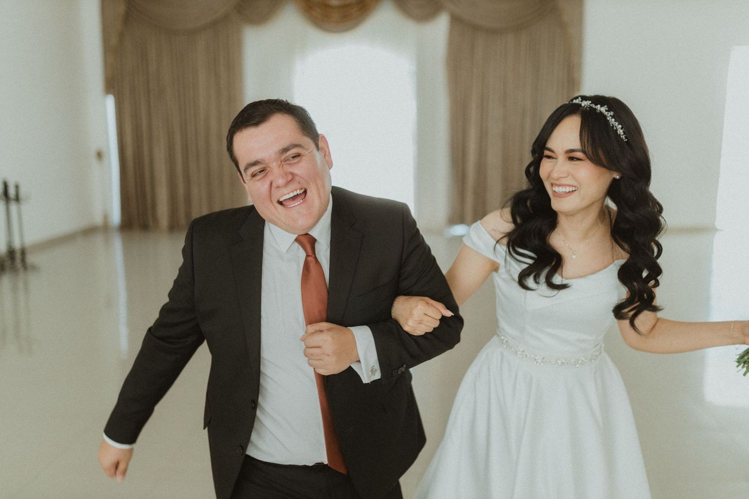 A joyful wedding moment captured in a bright, elegant indoor setting.