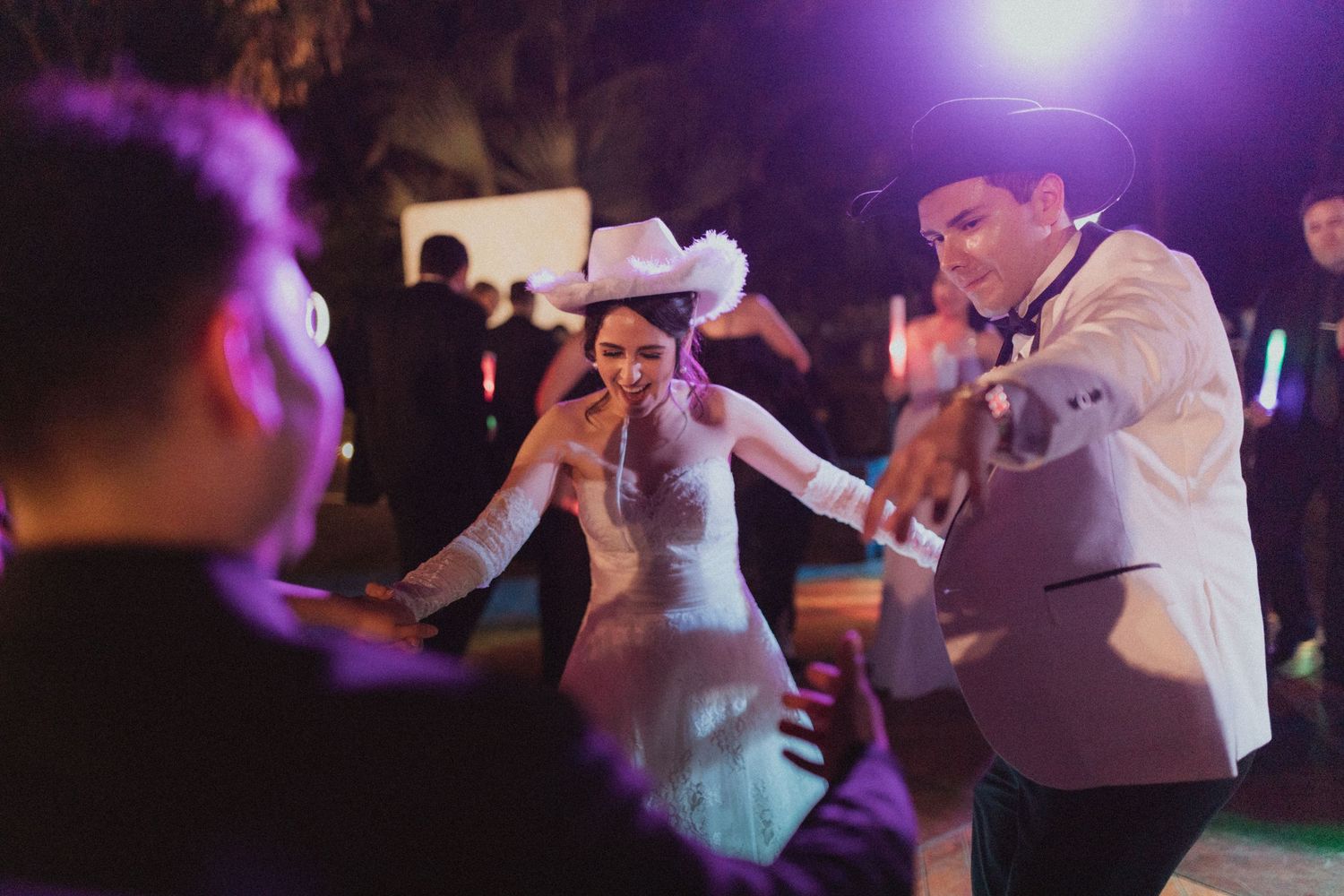 Wedding celebration dancing scene with festive lighting and evening atmosphere.