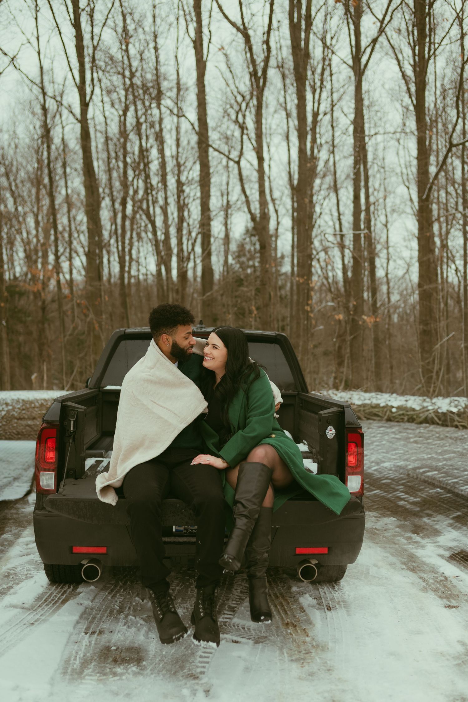 Four sequential photos show two people sitting in the back of a pickup truck in a snowy winter landscape.