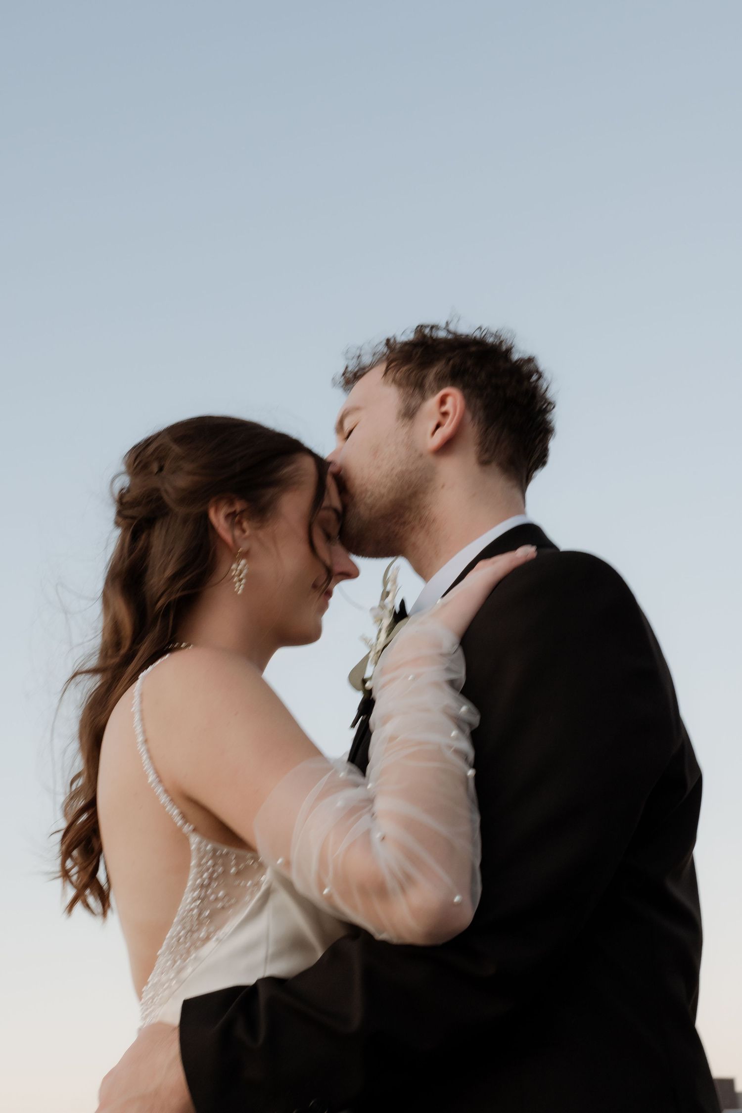 A romantic sequence of four wedding couple photos showing tender kisses in soft lighting at sunset.