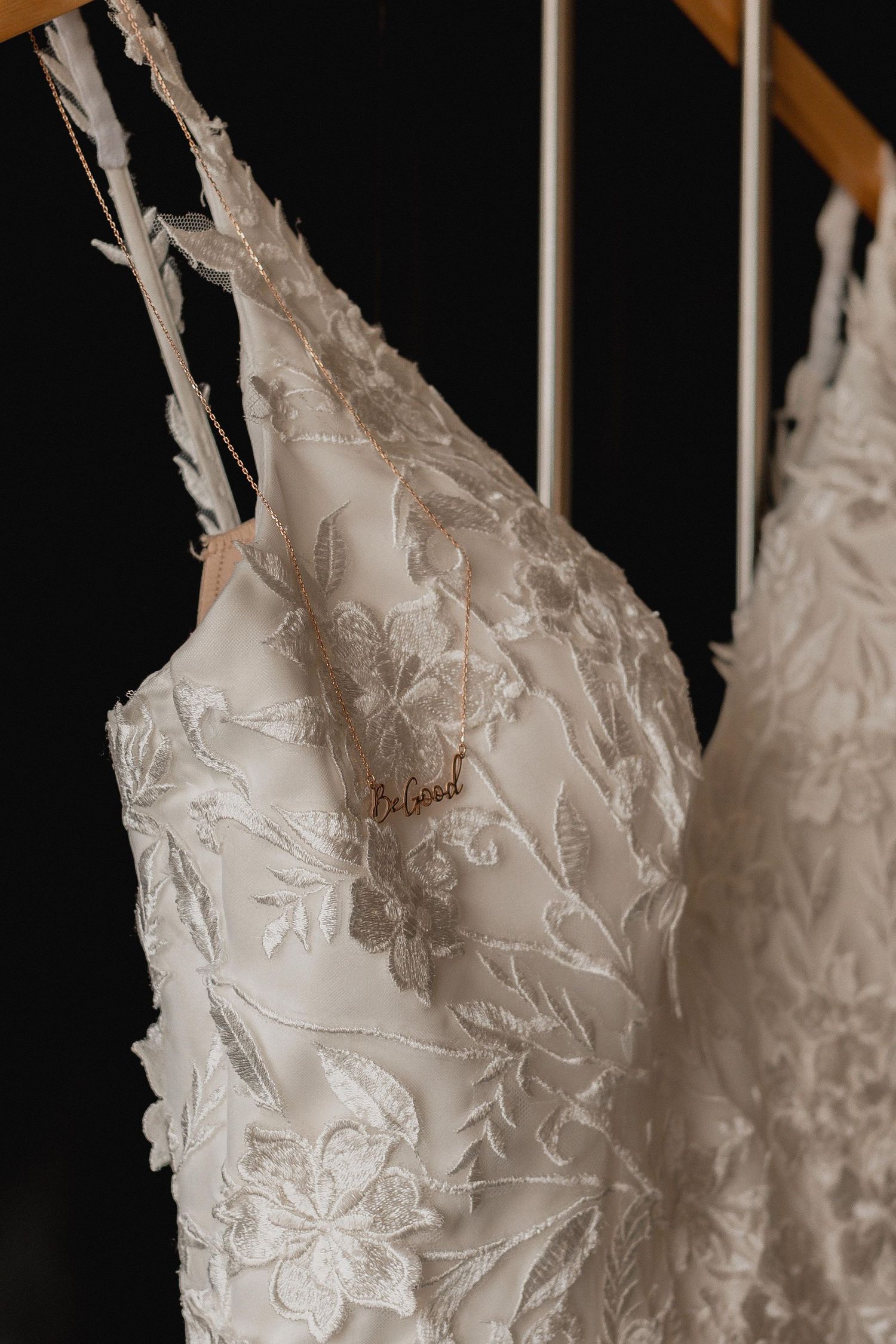 Close-up details of delicate white lace and floral embroidery on a wedding dress bodice.