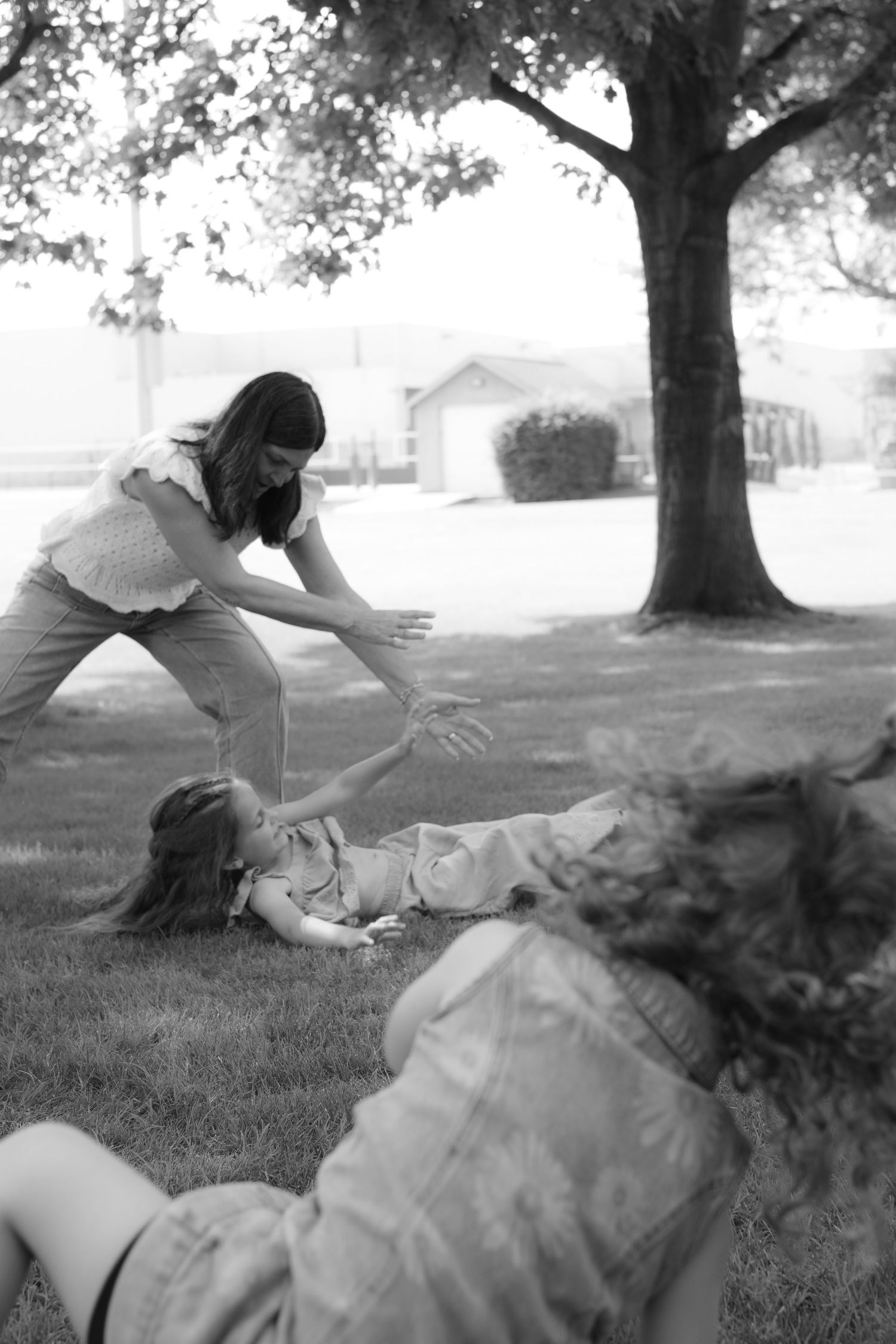 A sequence of black and white photos shows a person in a dress falling gracefully onto grass under a tree.