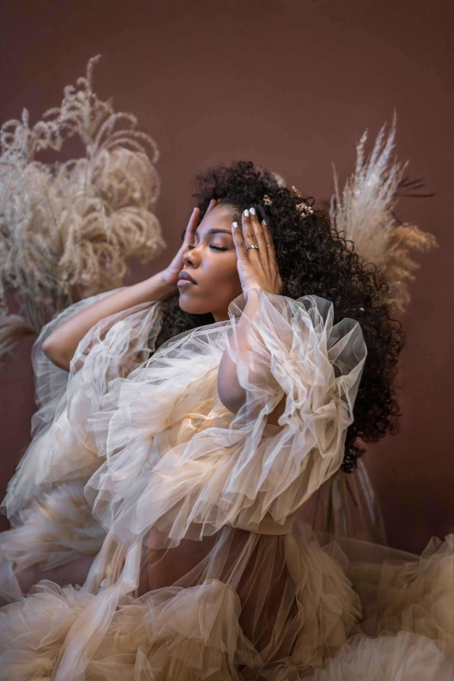 Artistic portrait series showing ethereal movement in flowing white tulle fabric against a dark brown background.
