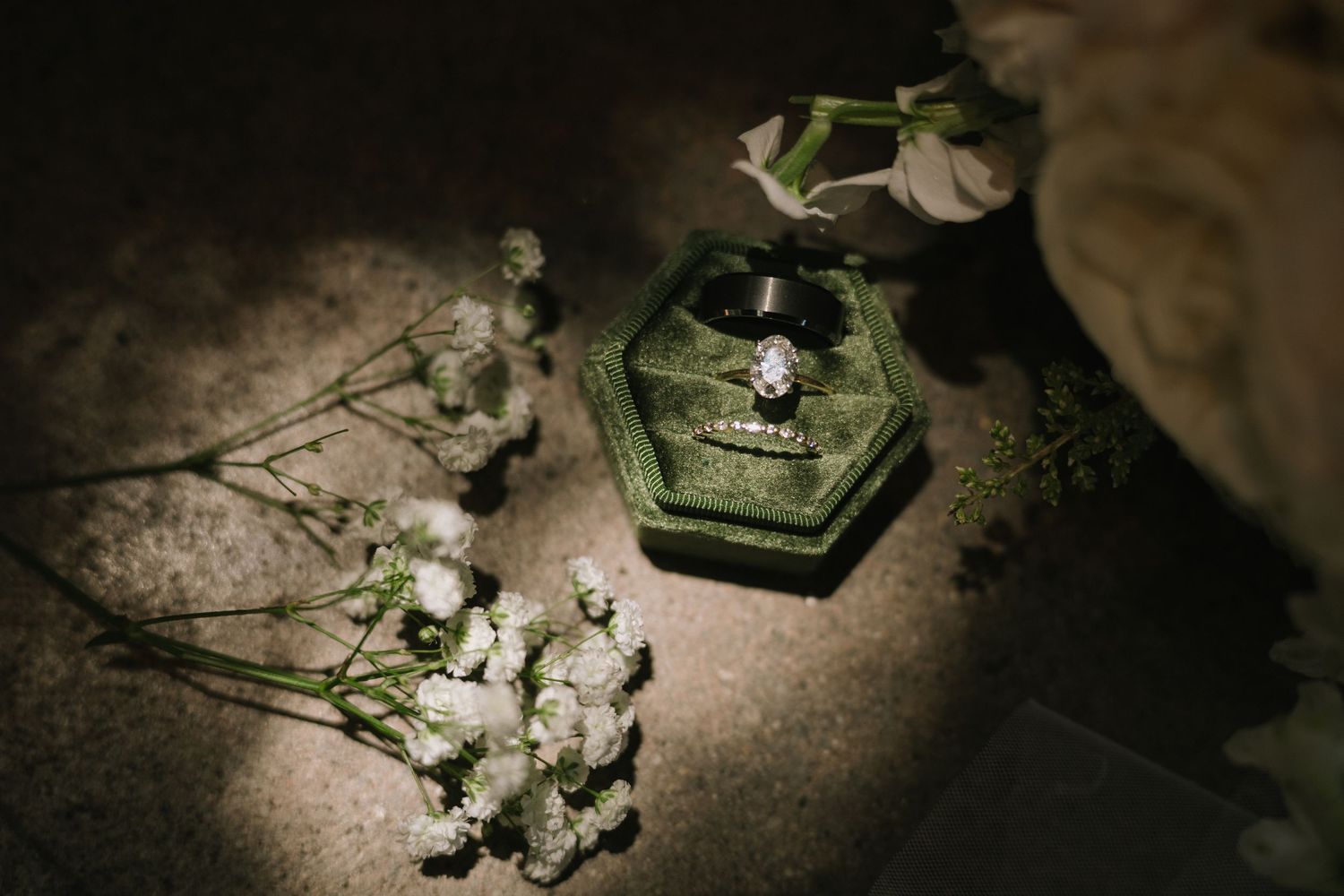 White flowers in moody lighting arrangements against a dark textured background in a vintage style series.