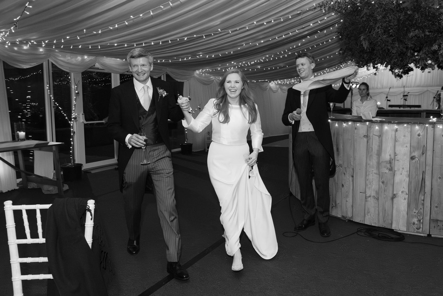 Wedding reception venue with twinkling lights and decorative ceiling draping.