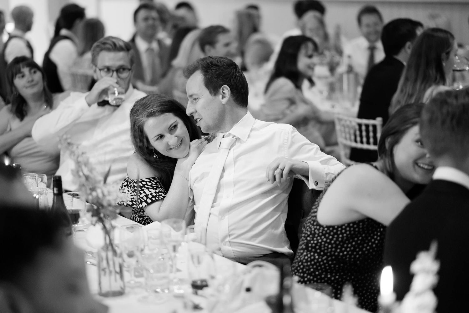 Wedding reception candid showing guests enjoying dinner at decorated tables.