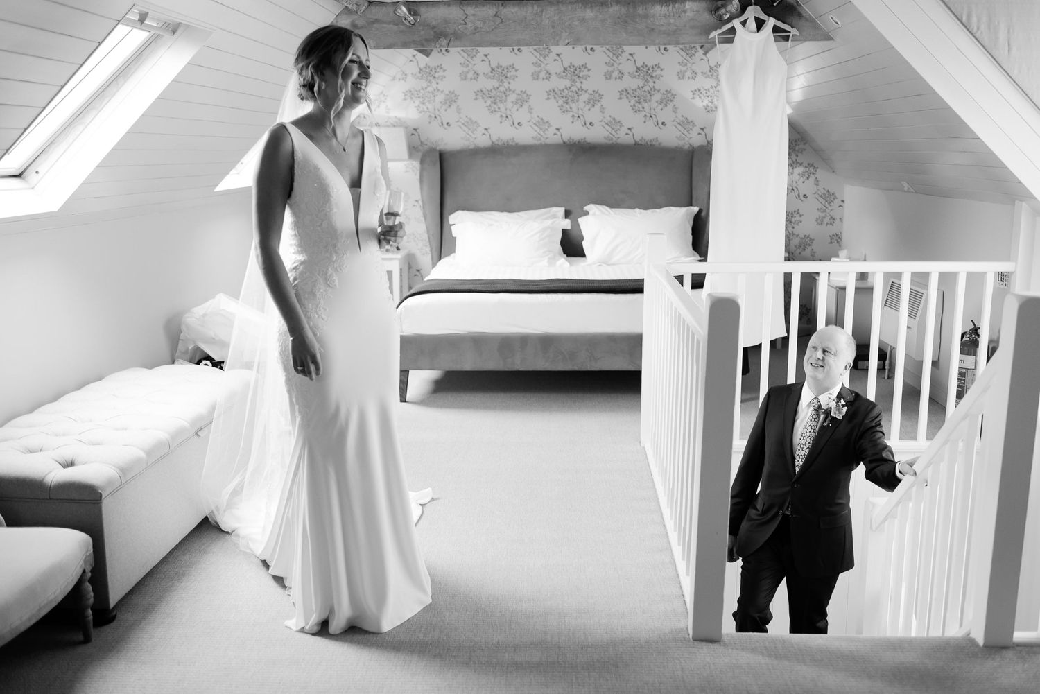 Candid moment captured between levels during wedding day preparations in attic suite.