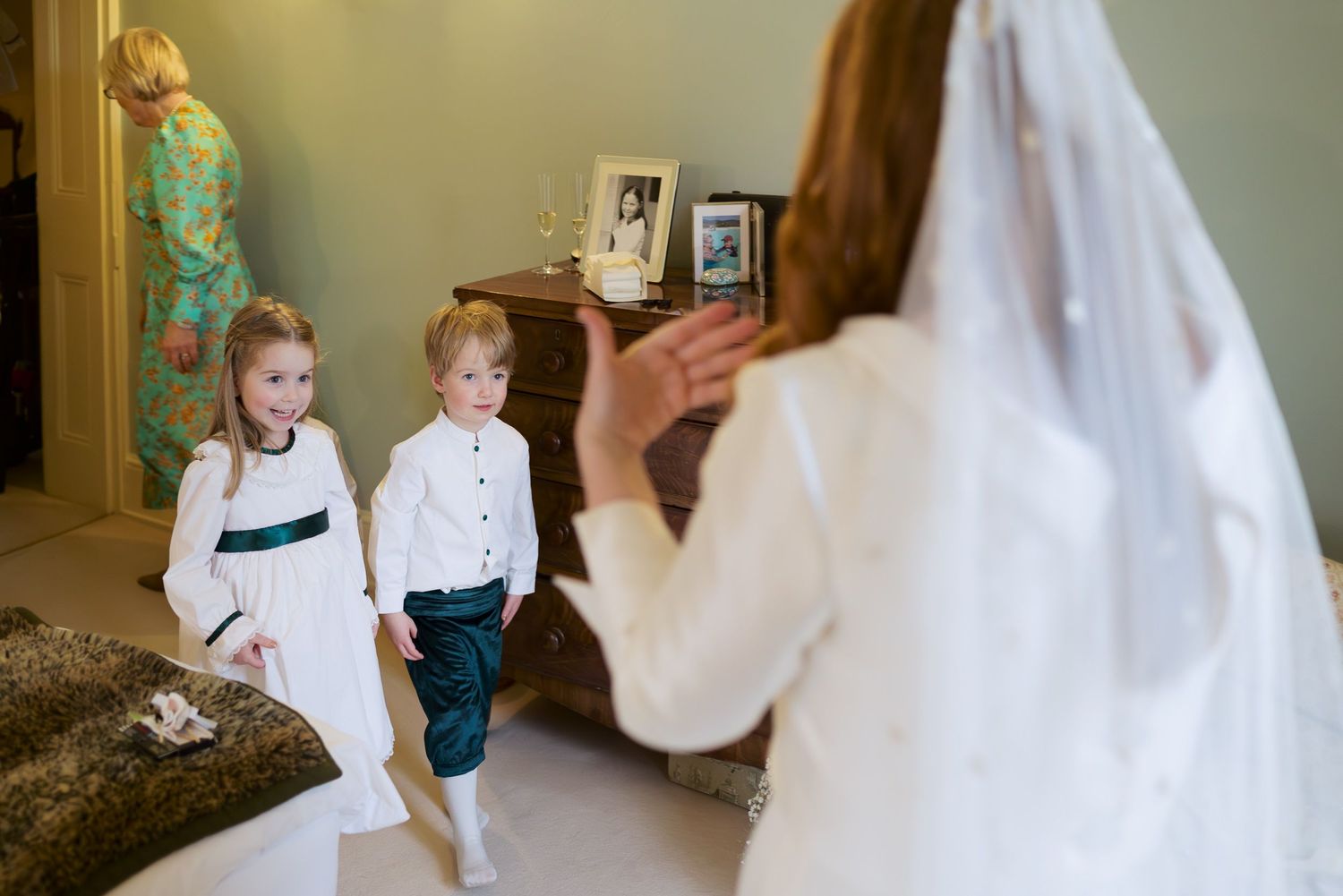 Wedding party descending elegant white staircase in formal attire during preparation moments.