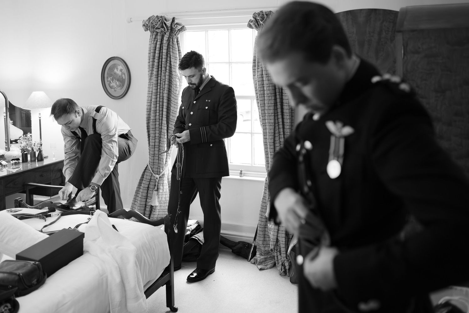 Black and white collage of wedding preparation moments showing people getting dressed and ready for a formal event.