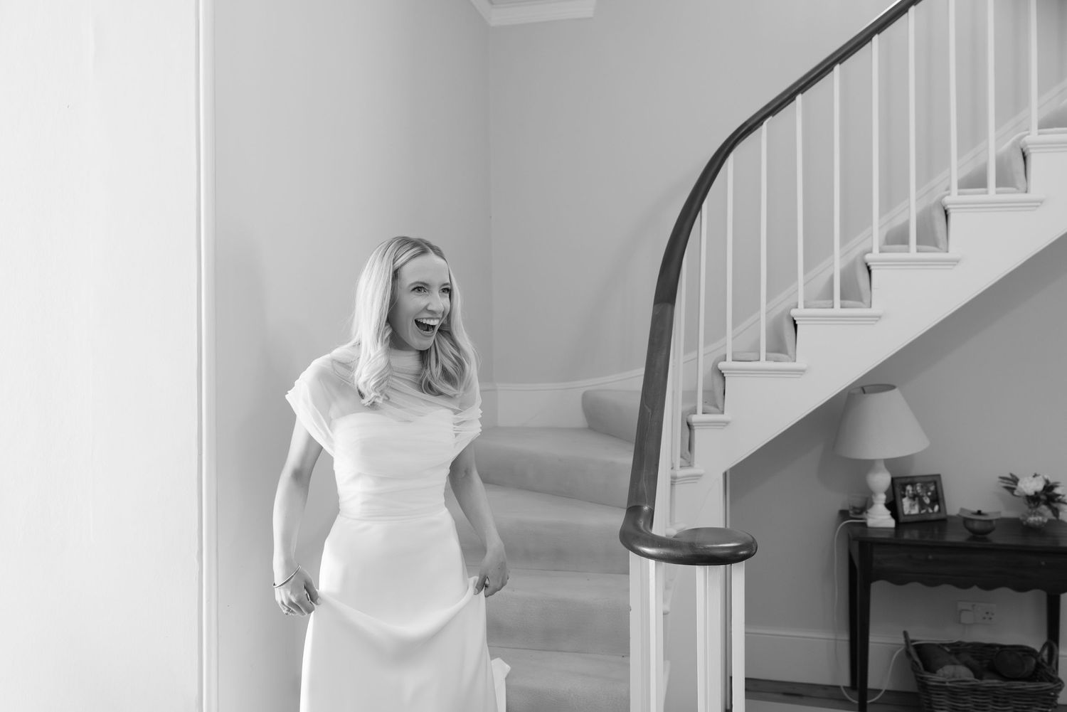 Interior staircase scene with white banister and grey walls in natural light.