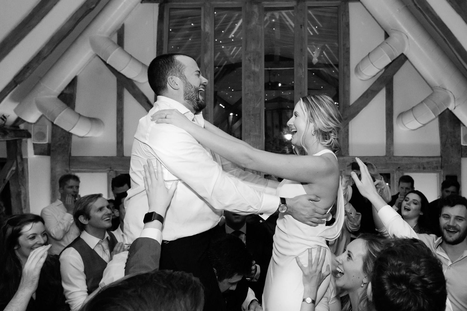Couple shares a romantic dance lift during their wedding celebration.