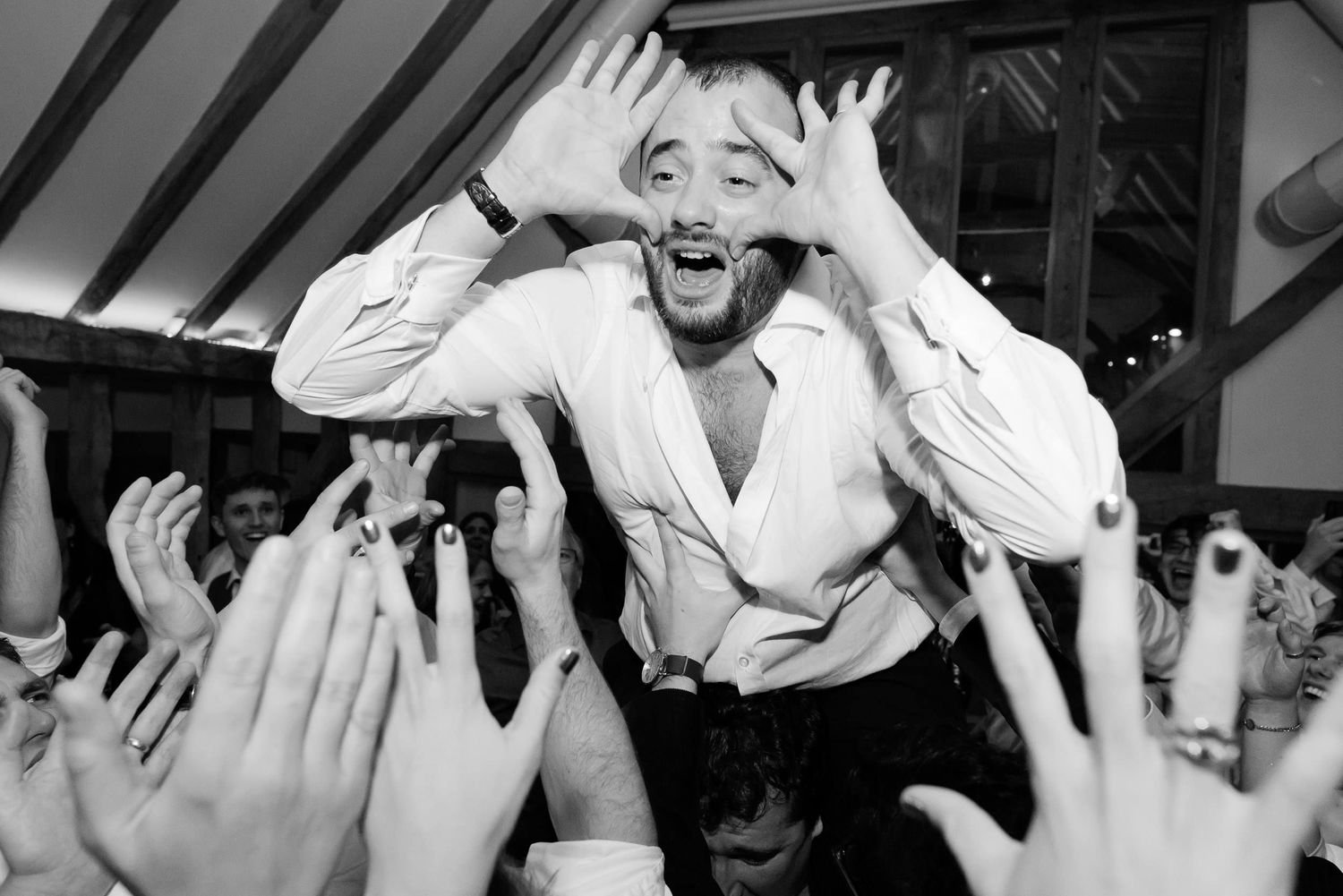 Celebratory moment at a wedding reception with raised hands and joyful expressions.
