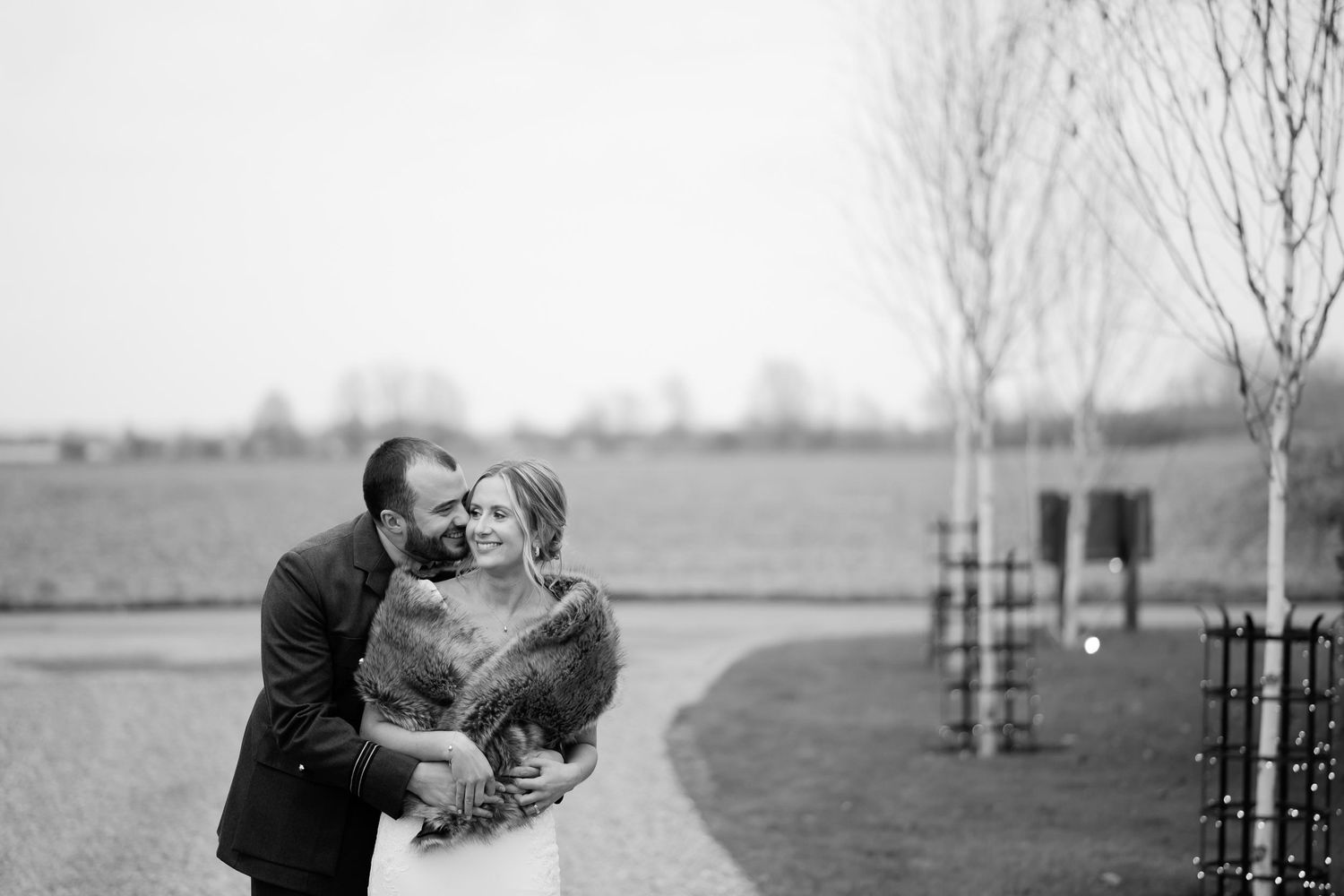 A romantic black and white wedding portrait captured outdoors on a winter day.