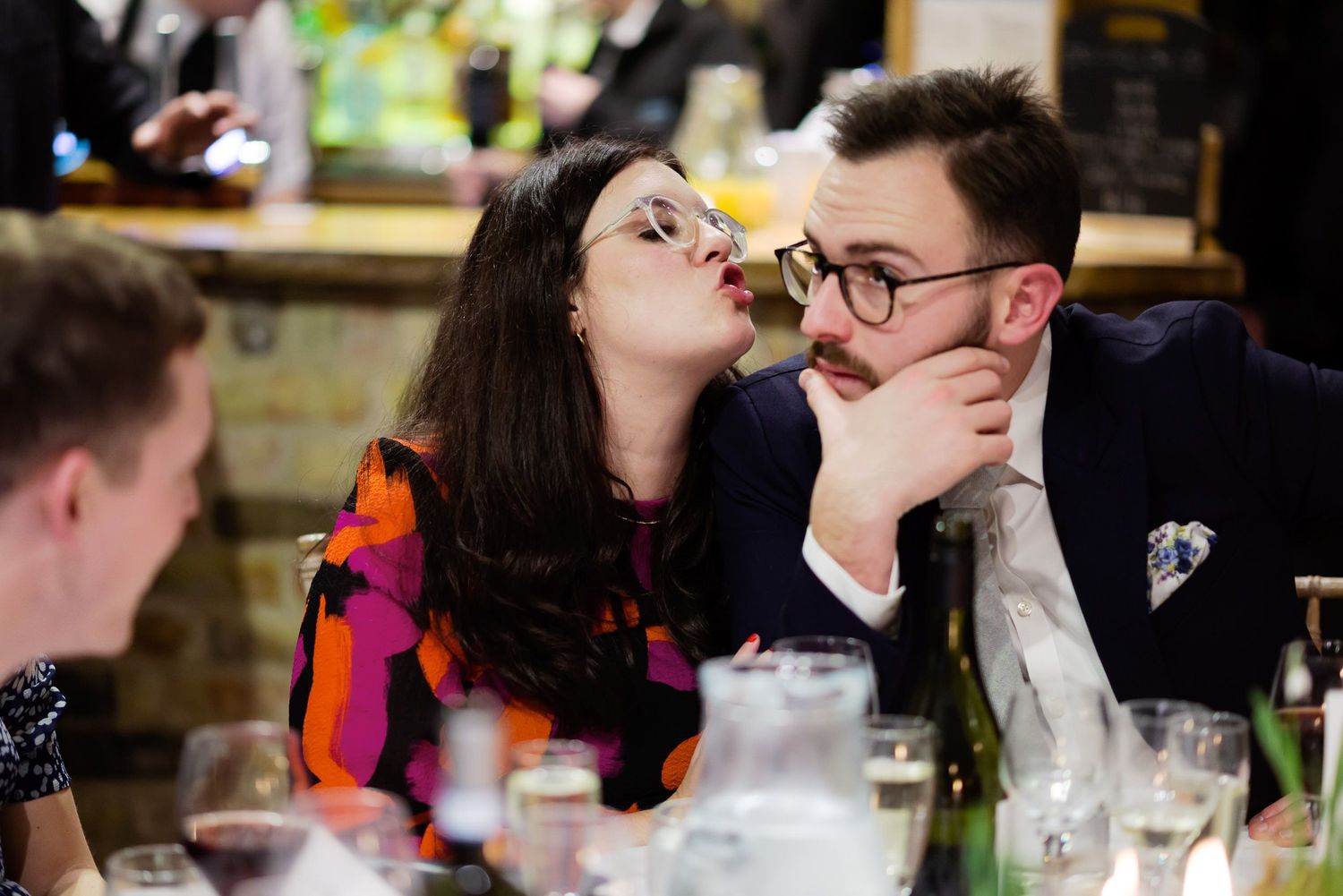 Playful moment captured between guests during wedding reception dinner.