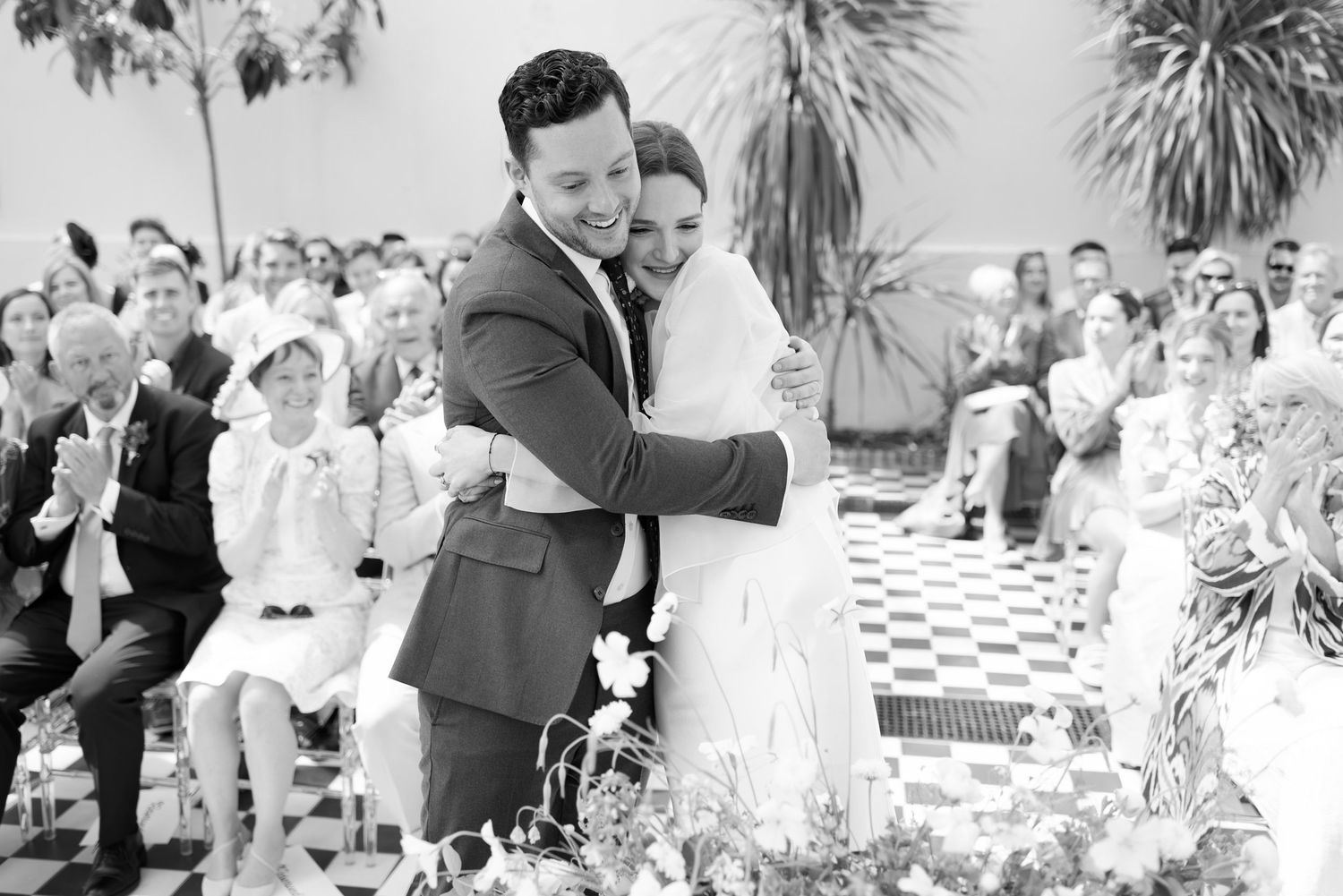Black and white photo collage showing multiple wedding scenes with guests dancing and celebrating at an outdoor reception.