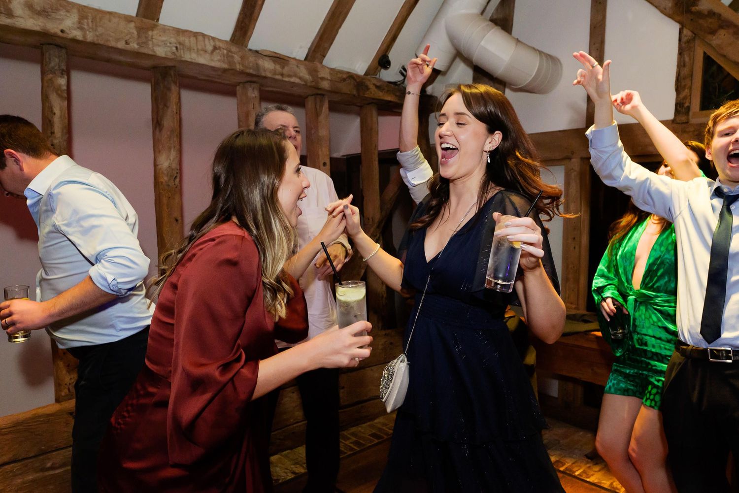 Party guests dancing and singing together at a festive indoor celebration.
